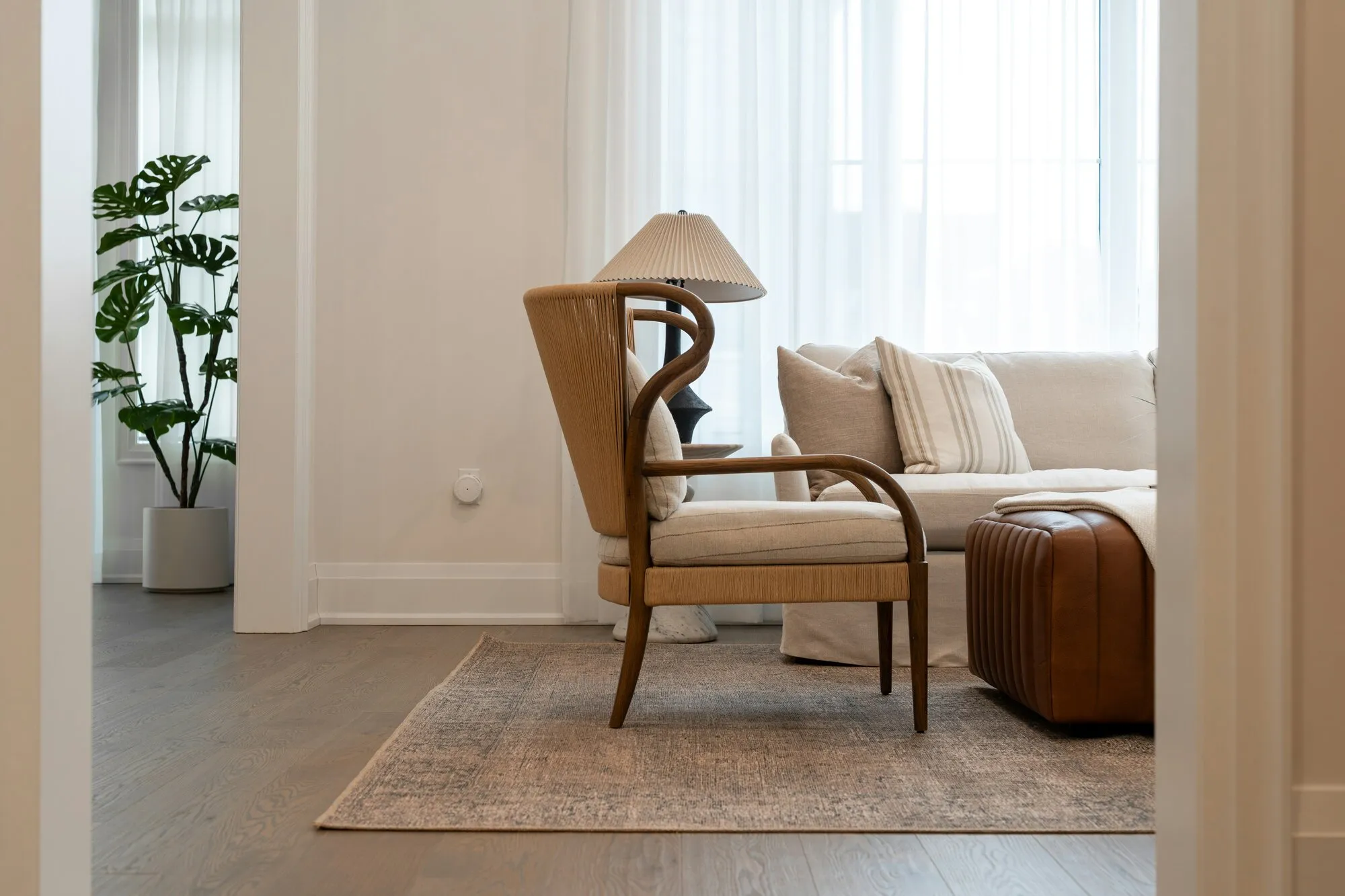 Salon soigné, fauteuil en bois et lampe posée sur un tapis : de beaux objets réunis dans une pièce, pas encore un système