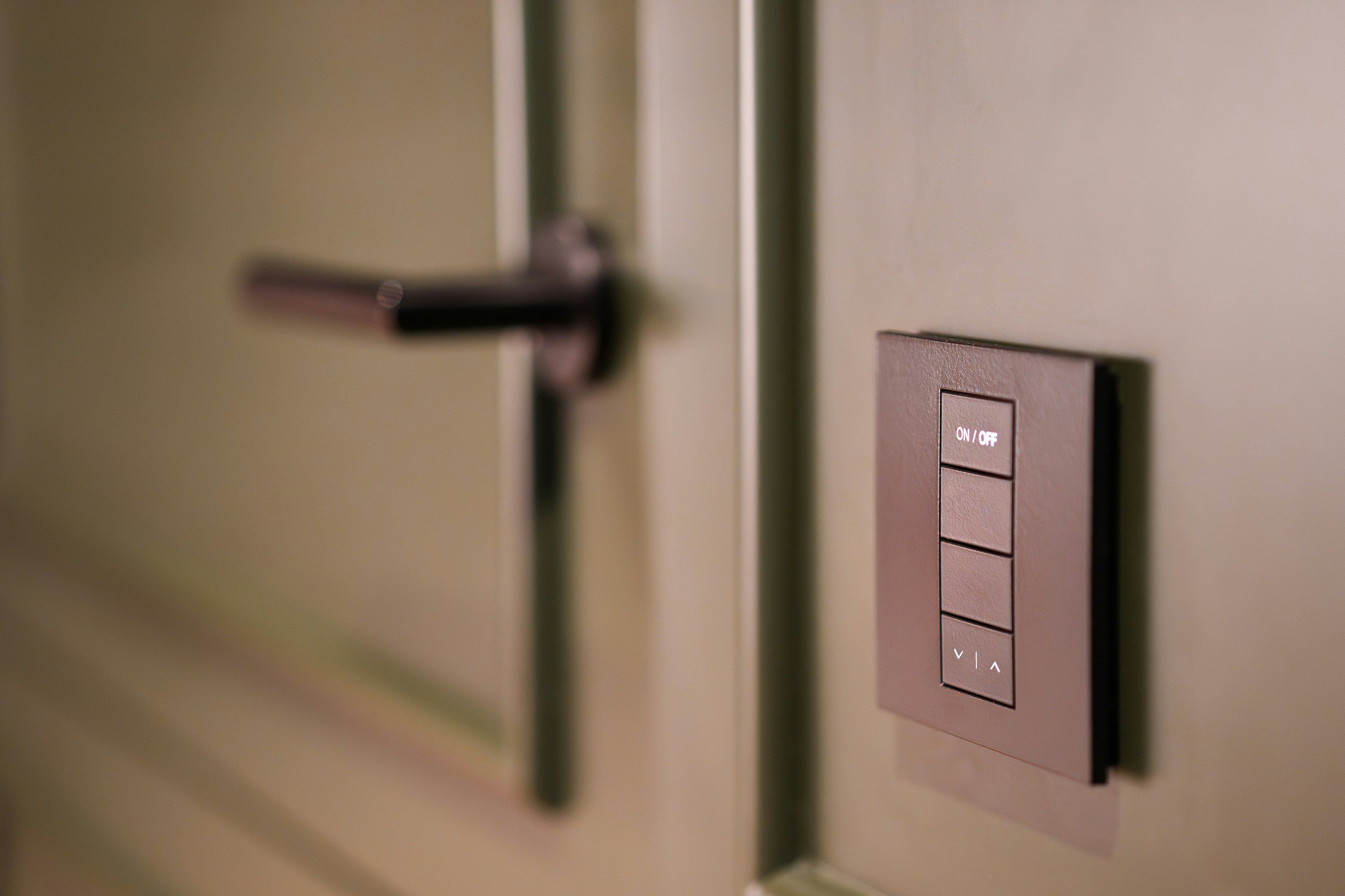 Module de commande murale discret près d'une porte, intelligence intégrée sans dispositif visible